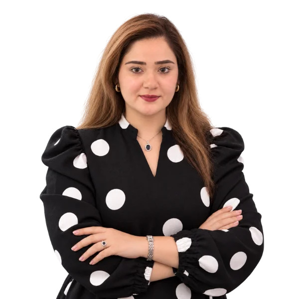 Syeda Hina Zahra, Human Resources Manager, smiling with arms crossed in a black polka-dot blouse